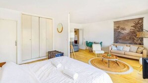 Un dormitorio con una cama grande, un armario y un comedor con mesa y sillas.