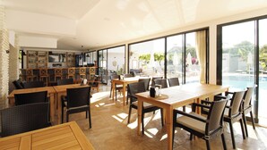 A spacious indoor area with a pool view, featuring a bar, dining area, and seating by the pool. - Tufan Boutique Hotel & Apart (Ortaca)