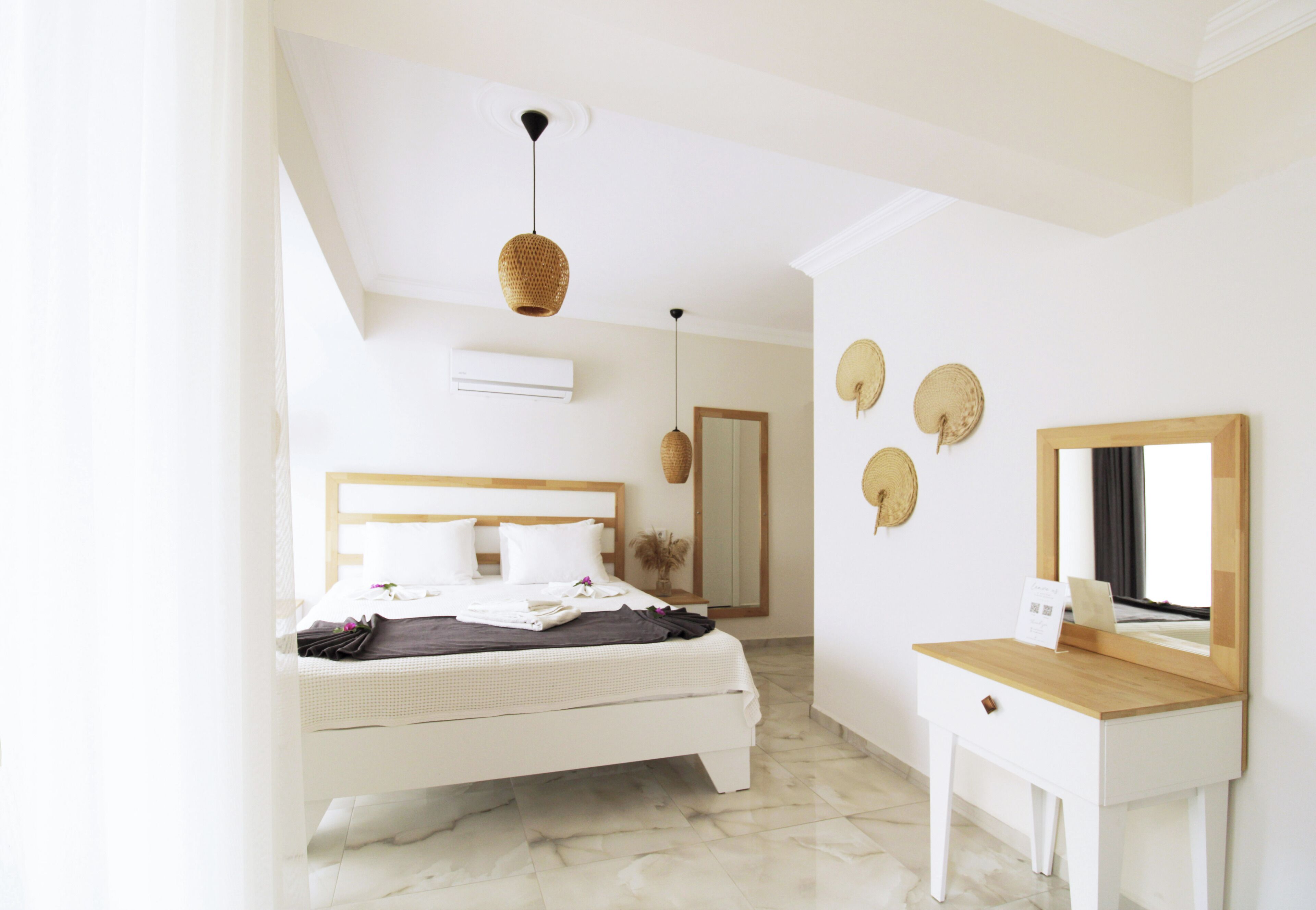 A bedroom with a bed, bedside table, and a mirror.