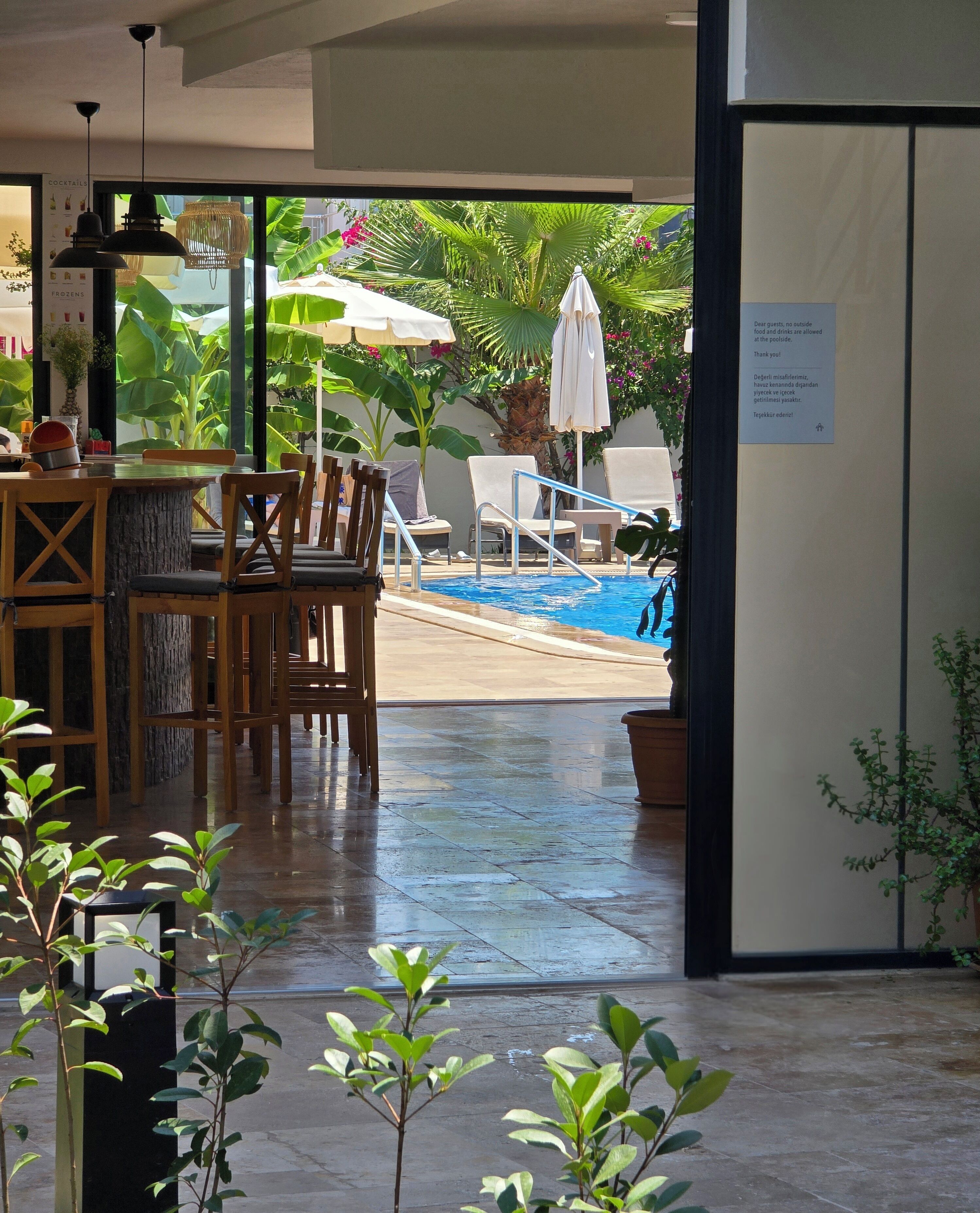 A poolside area with lounge chairs and a dining table.