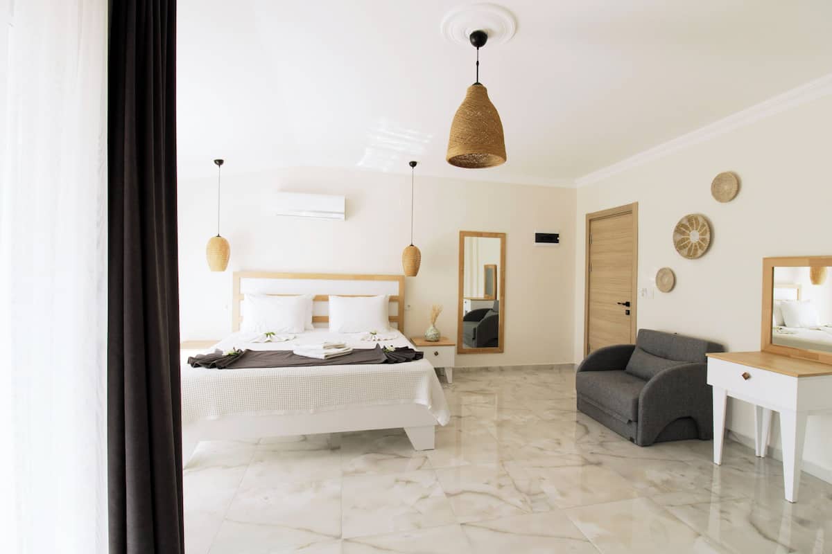 Une chambre à coucher moderne avec un lit, une table de chevet et un fauteuil gris.