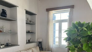 A living room with a sofa, a coffee table, a potted plant, and a laptop. - Tinos - House - Sleeps 5 - Pet Friendly - Parking (Tinos)