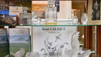 Una exhibición de frascos de perfume y objetos decorativos de René Lalique sobre un estante de vidrio.