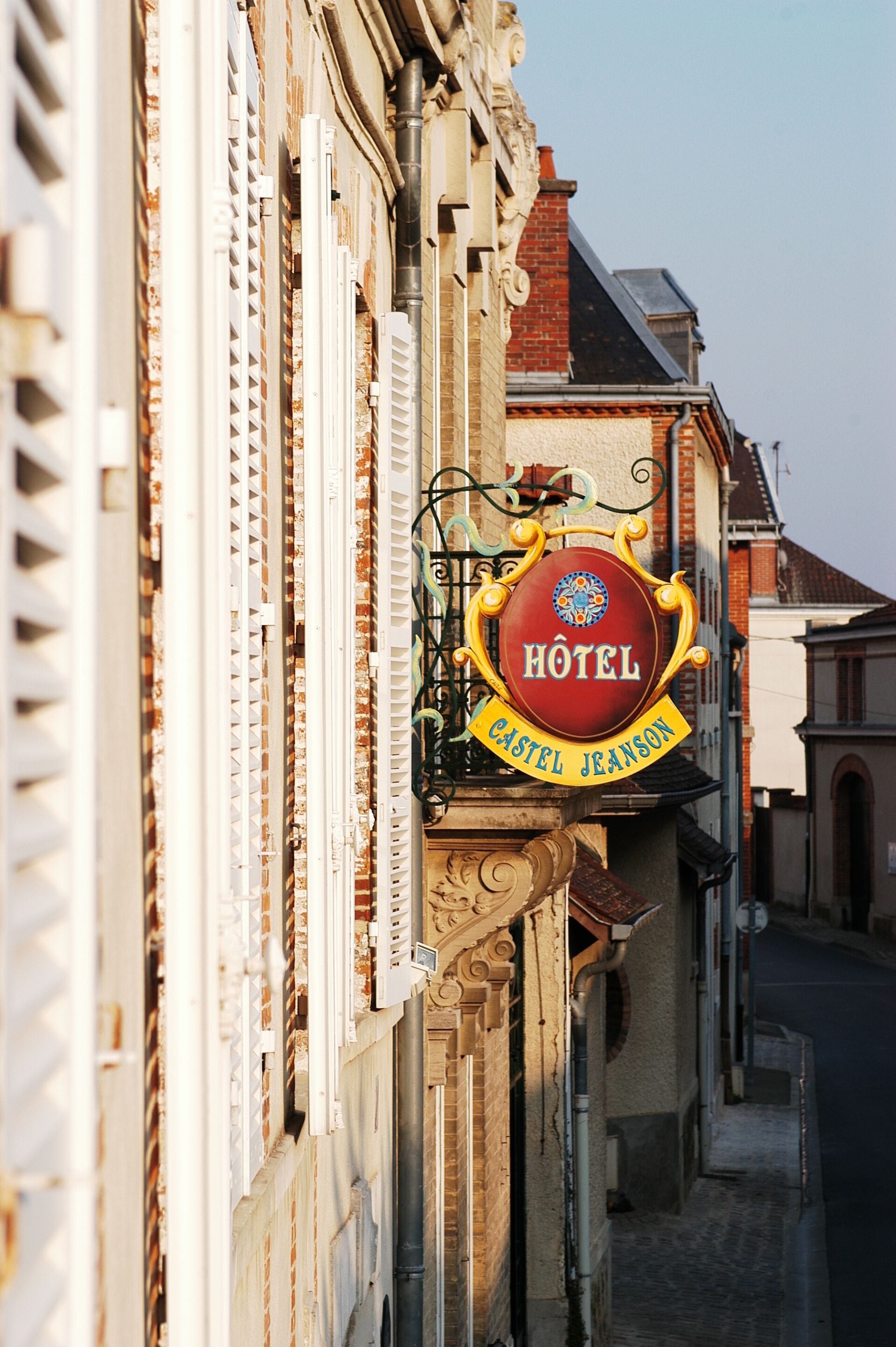 Une enseigne d’hôtel portant le nom « CASTEL JEANSON » est fixée à un bâtiment.