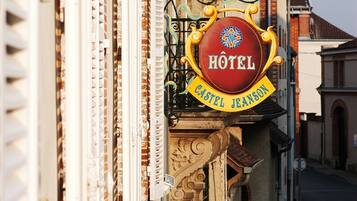 A hotel sign with the name "CASTEL JEANSON" on a building.