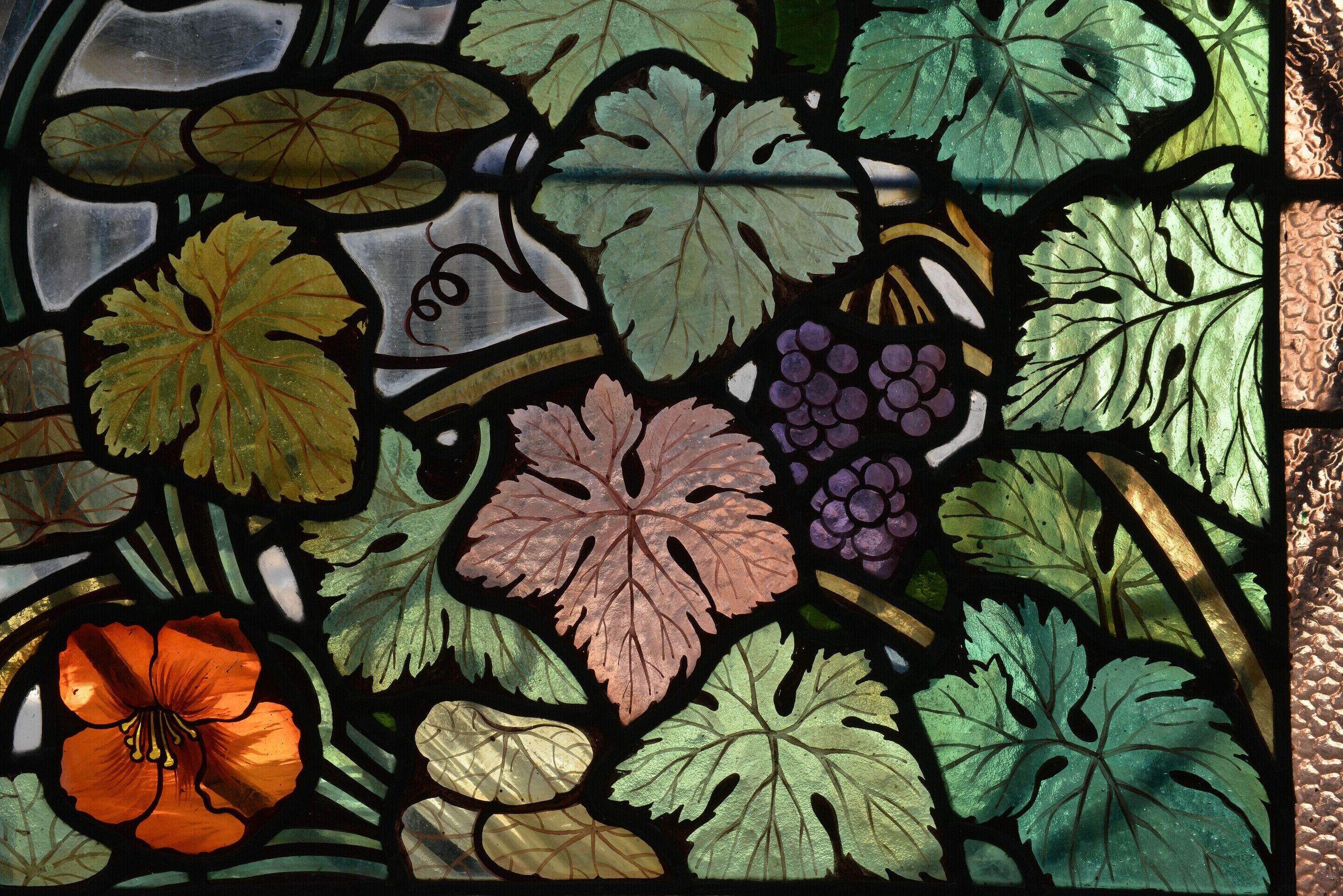 A stained glass window with various leaf patterns.