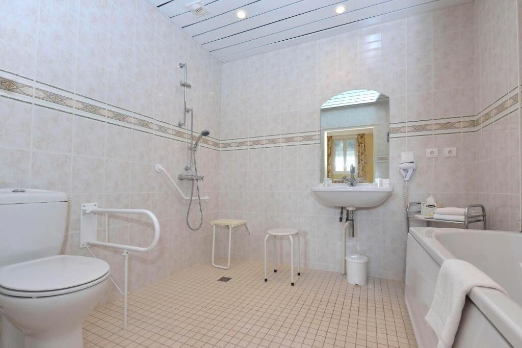 Un baño con inodoro, lavabo, ducha y bañera.