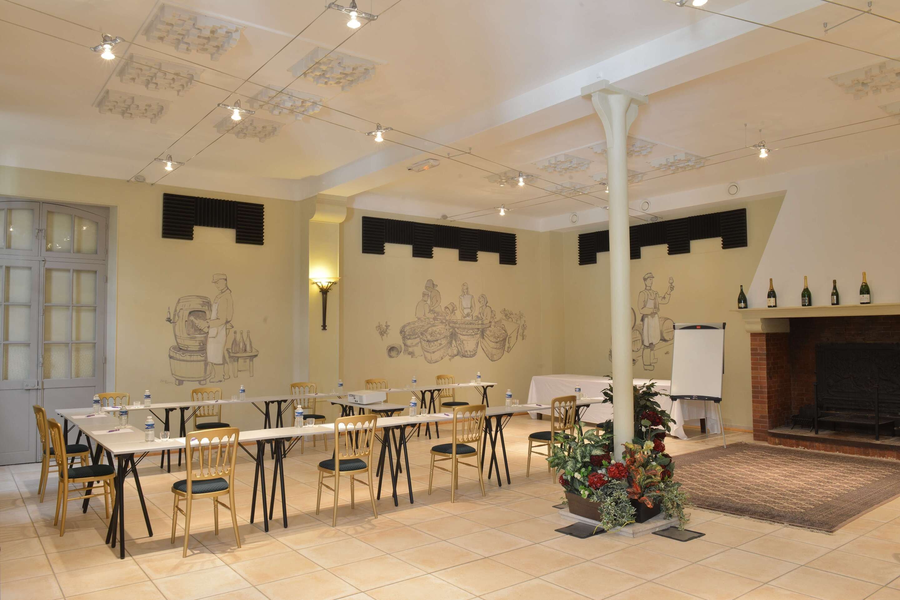 A conference room with tables and chairs, a fireplace, and wall murals.