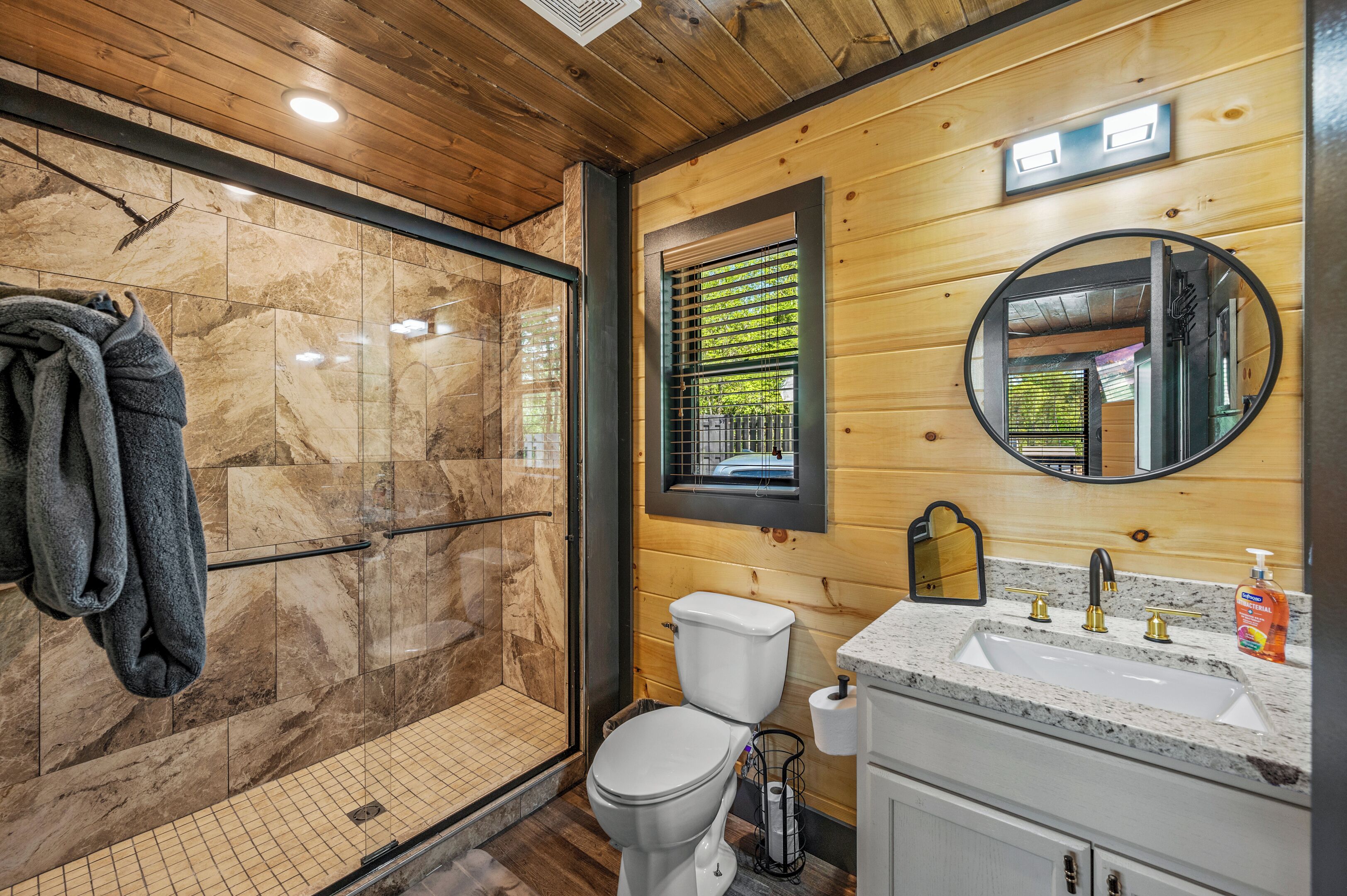 Un bagno con doccia, servizi igienici, lavandino e specchio.