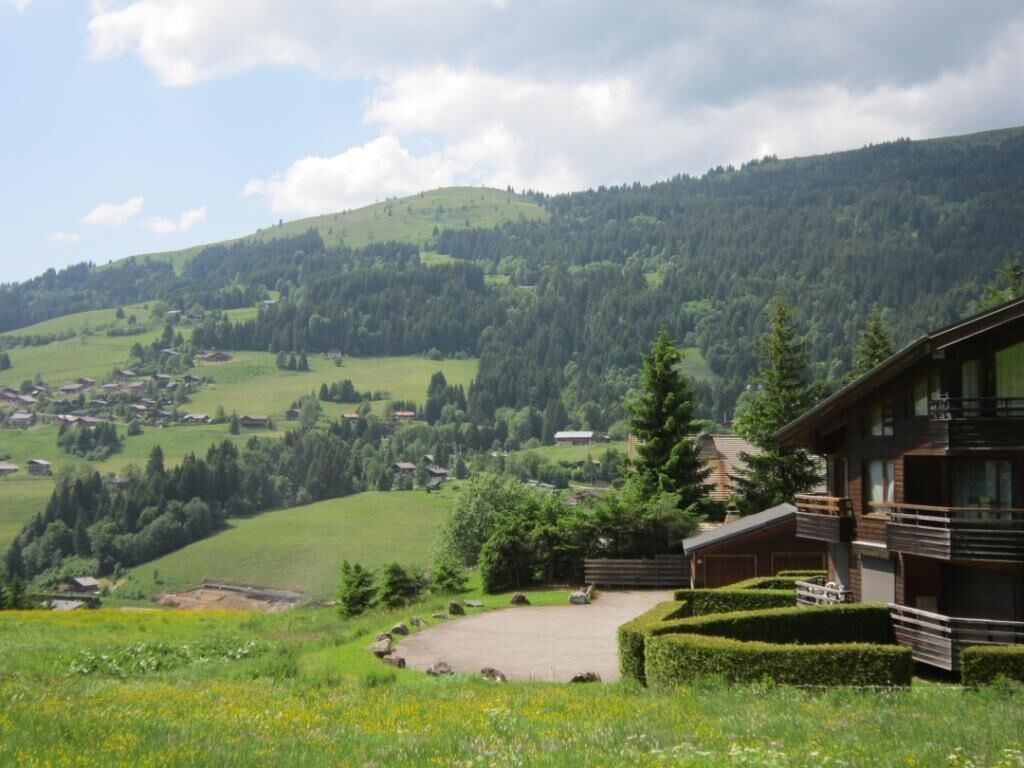 Eine Berglandschaft mit einer Holzhütte und freiem Blick auf das Tal.