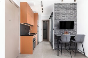 Enjoy casual dining and socializing in this kitchen with TV, bar stools, and a small table.