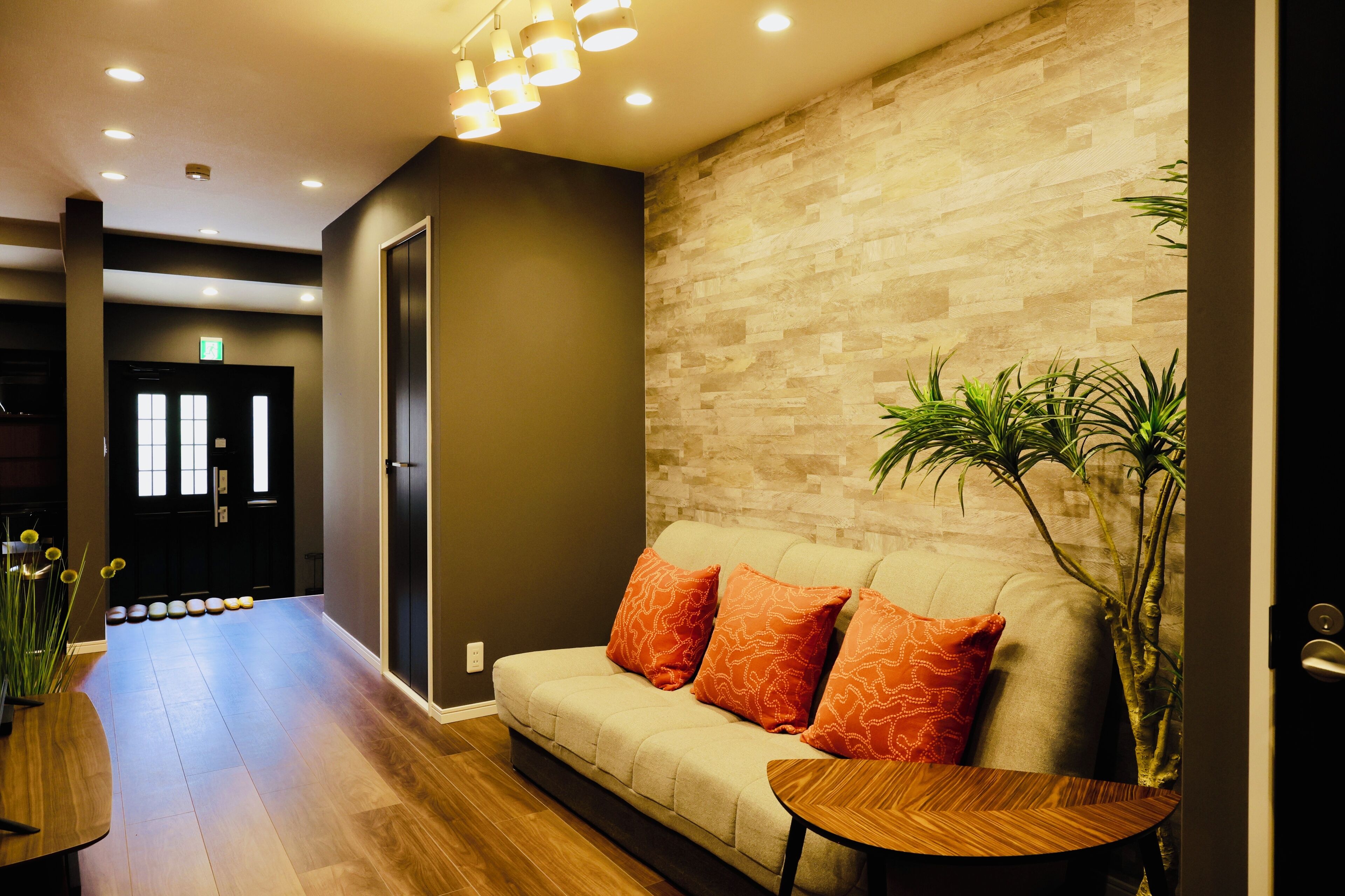 A modern lobby with a sofa, a small table, and a potted plant.