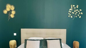 A bed with a quilted headboard, two pillows, and a bedside table with a lamp. - Résidence DOMITYS - Les Séquanes (Chalon-sur-Saone)