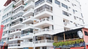 A multi-story hotel with balconies, a visible restaurant named "Los Helechos," and several parked cars. - Apartment - Sleeps & Free Parking (Salinas)