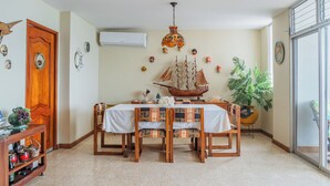 A dining area with a wooden table, chairs, and a ship model centerpiece. - Apartment - Sleeps & Free Parking (Salinas)