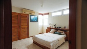 A bedroom with a large bed, wooden wardrobe, and a desk with a lamp. - Apartment - Sleeps & Free Parking (Salinas)