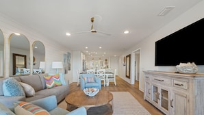 A spacious living room with a sofa, coffee table, and TV. - Needle Rush Point D11 (Pensacola)