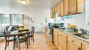 A modern kitchen with wooden cabinets, a granite countertop, and stainless steel appliances. - 3 Mi to Boardwalk: Bacliff Apartment w/ Hot Tub (Bacliff)