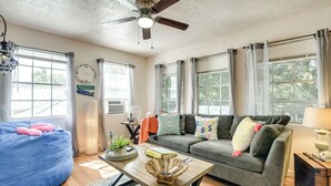 A cozy living room with a blue bean bag, a gray sofa, a wooden coffee table, and a ceiling fan. - 3 Mi to Boardwalk: Bacliff Apartment w/ Hot Tub (Bacliff)