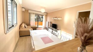 A modern living room with a sofa, TV, and a dining area with a table and chairs. - Antibes - 4 people - Parking (Antibes)
