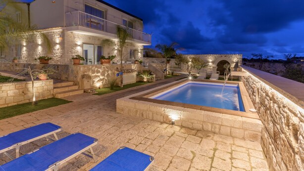 A modern house with a swimming pool, stone walls, and potted plants. - Villa Ariana - Standard Room (Gatto Corvino)