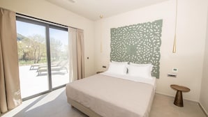 A modern bedroom with a large bed, a sliding glass door to a patio, and a decorative wall panel. - Villa Selena in Ionian Islands (Kefalonia)