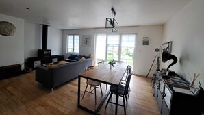 Ein modernes Wohnzimmer mit einer Couch, einem Esstisch und einem Kamin.