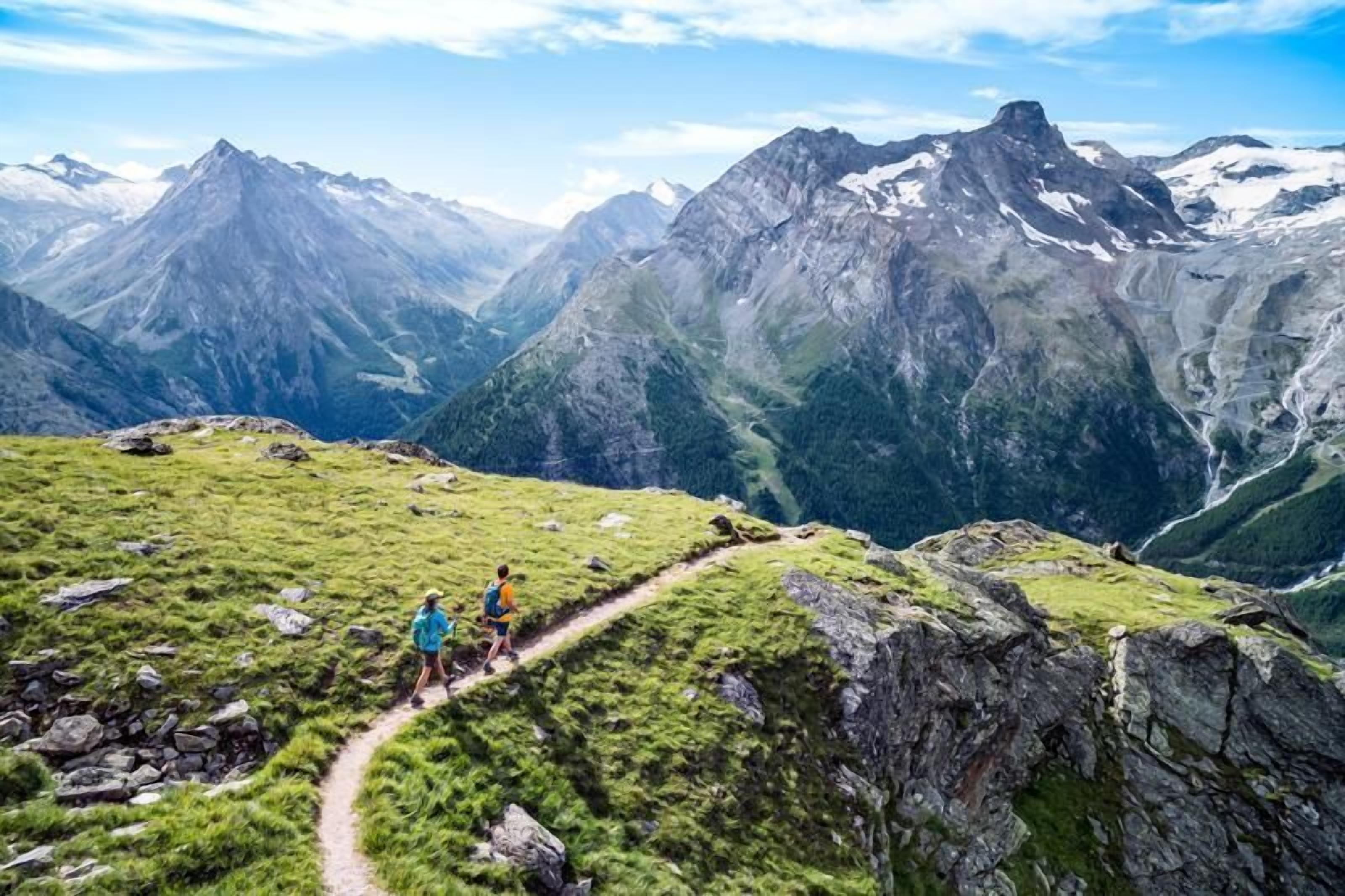 A mountain hiking trail with rocky terrain and lush greenery.