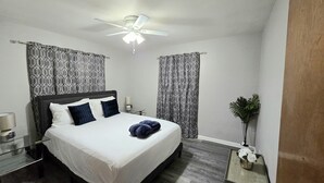 A neatly made bed with a headboard, a bedside table with a lamp, a ceiling fan, and a potted plant. - First floor 1Bed/1Bth Pets OK, Close to ProMedica, UT (Toledo)