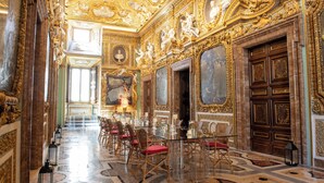 An opulent room with ornate gold detailing, a grand chandelier, and a long dining table set for a meal. - Palazzo Shedir - The Leading Hotels of the World (Rome)