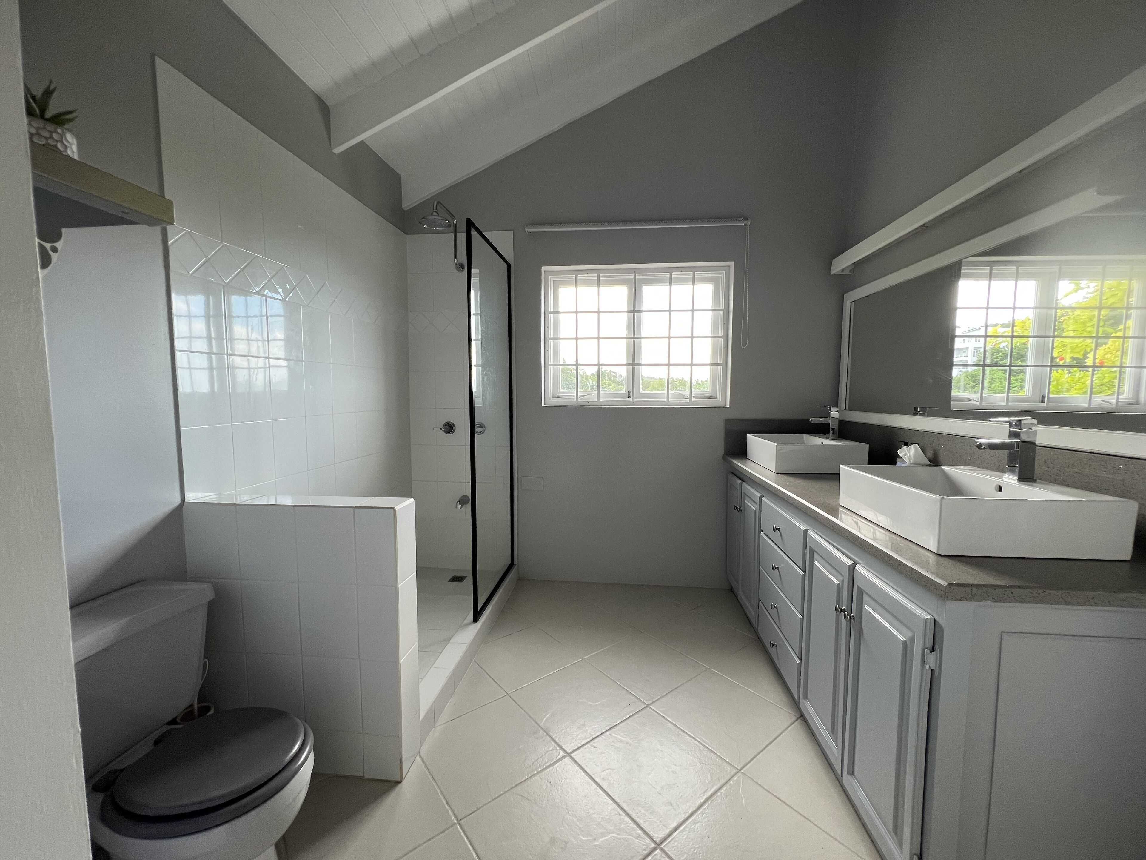 Une salle de bain moderne comprenant des toilettes, une douche et un espace lavabo.