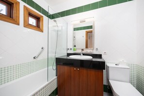 Une salle de bain équipée d’une baignoire, d’une douche, d’un lavabo et de toilettes.