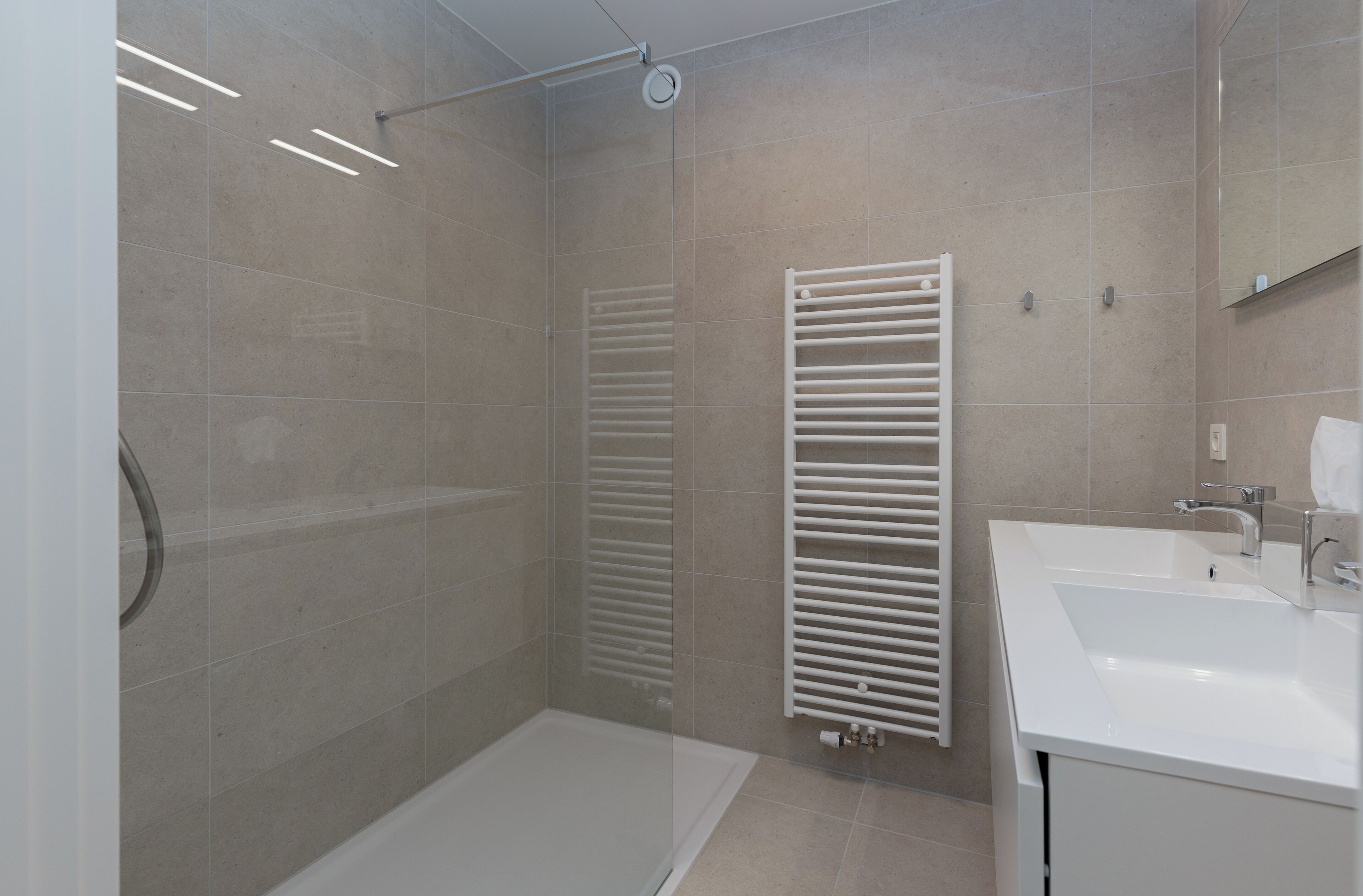 Un baño moderno con ducha, bañera y lavabo.