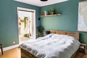 Relax in this serene bedroom with a large bed, nightstands, and a sliding door leading to an outdoor space.
