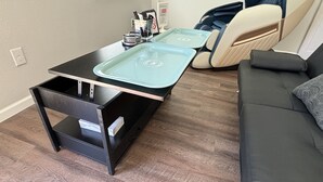 A compact living space with a kitchenette, a sofa, and a small table. - Zen Den - jetted tub, massage chair, home theater, EV charger, King bed, parking (Burleson)
