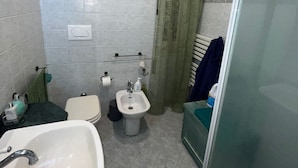 A bathroom with a sink, toilet, bidet, and shower area. - Specter Guesthouse (Nettuno)
