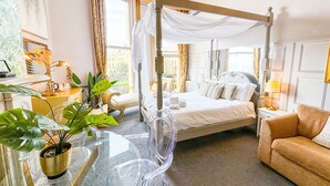 A four-poster bed with a canopy, a glass table with chairs, a sofa, and a potted plant. - The X Hotel (Hove)
