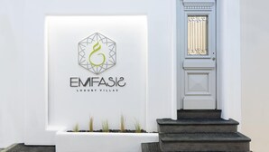 Fachada de un edificio blanco con un logotipo y el nombre "EMFASide Luxury Villas".
