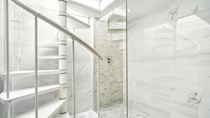A modern bathroom with a glass-enclosed shower, marble flooring, and a white spiral staircase. - 4 bedroom home by Buckingham Palace (London)