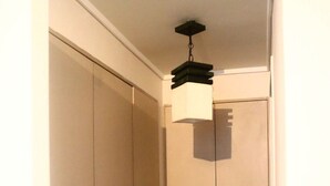 A narrow hallway with a closet and a hanging light fixture. - Tranquilo Departamento Full Equipado (Santiago)