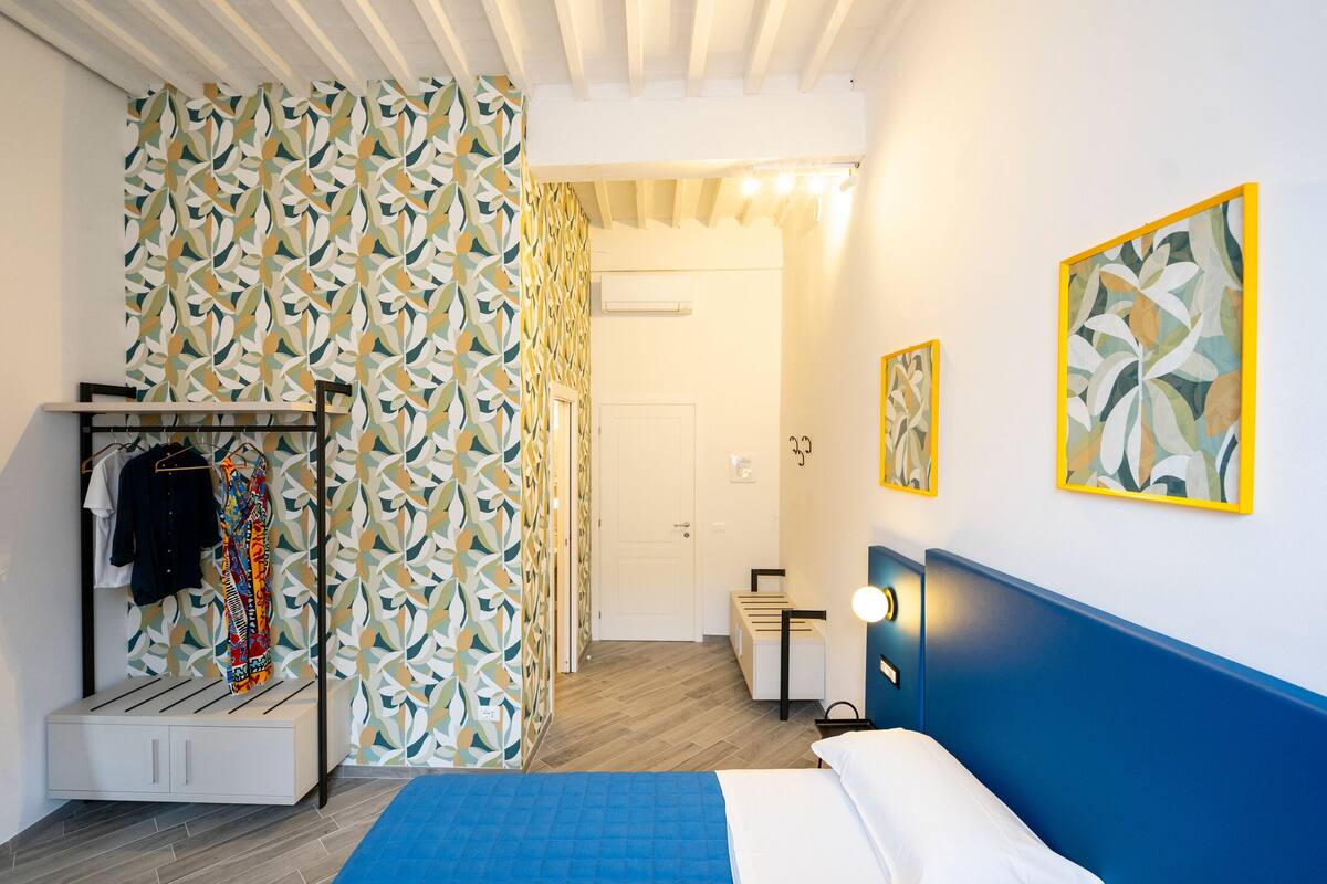 Een slaapkamer met een bed, een kledingkast en een spiegel.