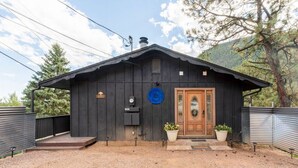 Une cabane rustique en bois, avec une porte en bois, un petit porche et un panneau circulaire bleu sur le mur.