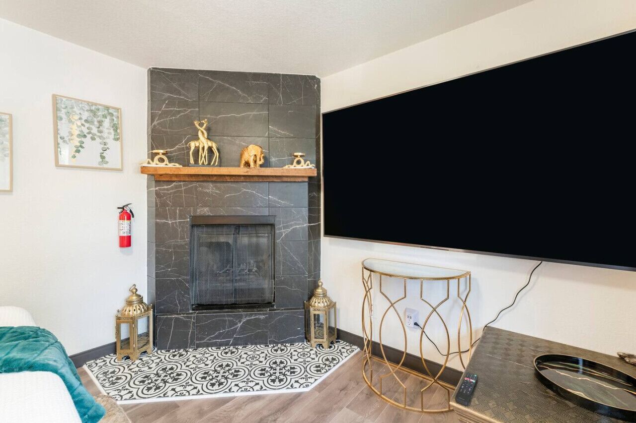 A modern room with a fireplace, a mounted TV, and a decorative shelf with figurines.