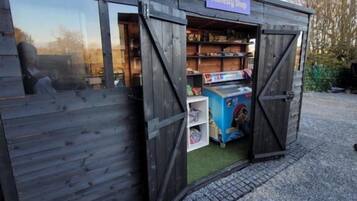 Un edificio de madera con un letrero que dice 'Honesty Shop' y un escaparate visible.