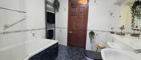 Un baño con bañera, inodoro y lavamanos.