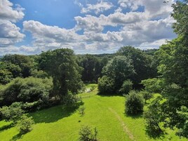 A lush green landscape with a clear sky and scattered clouds.