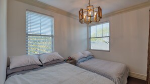 A bedroom with two beds, a wooden ceiling light fixture, and windows with blinds. - Luxury 2 bed 1 bath in nice neighborhood. (Torrance)