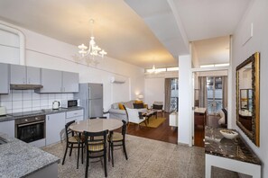 A modern kitchen with a dining area, a living room, and a bathroom.