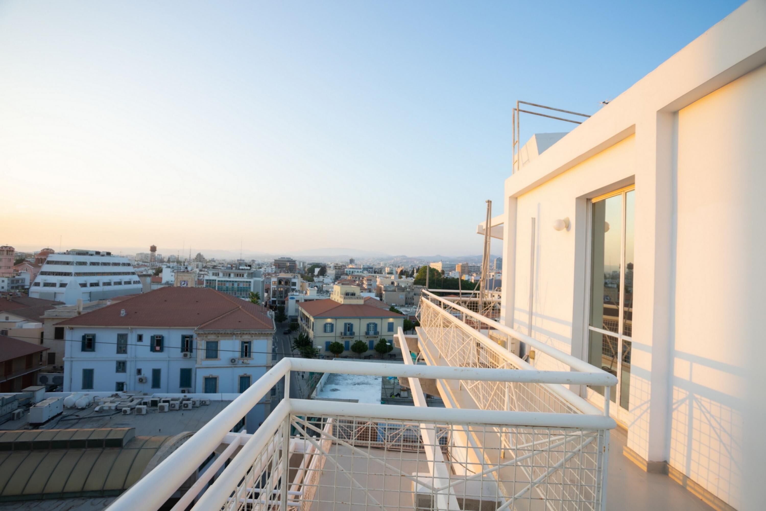 A high-rise building with a balcony overlooking a cityscape.