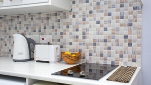 Una cucina con una macchina da caffè Bosch, un tostapane e una ciotola con limoni su un piano di lavoro bianco.